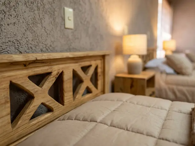 Detalle de cama de madera y ropa de cama en una habitación